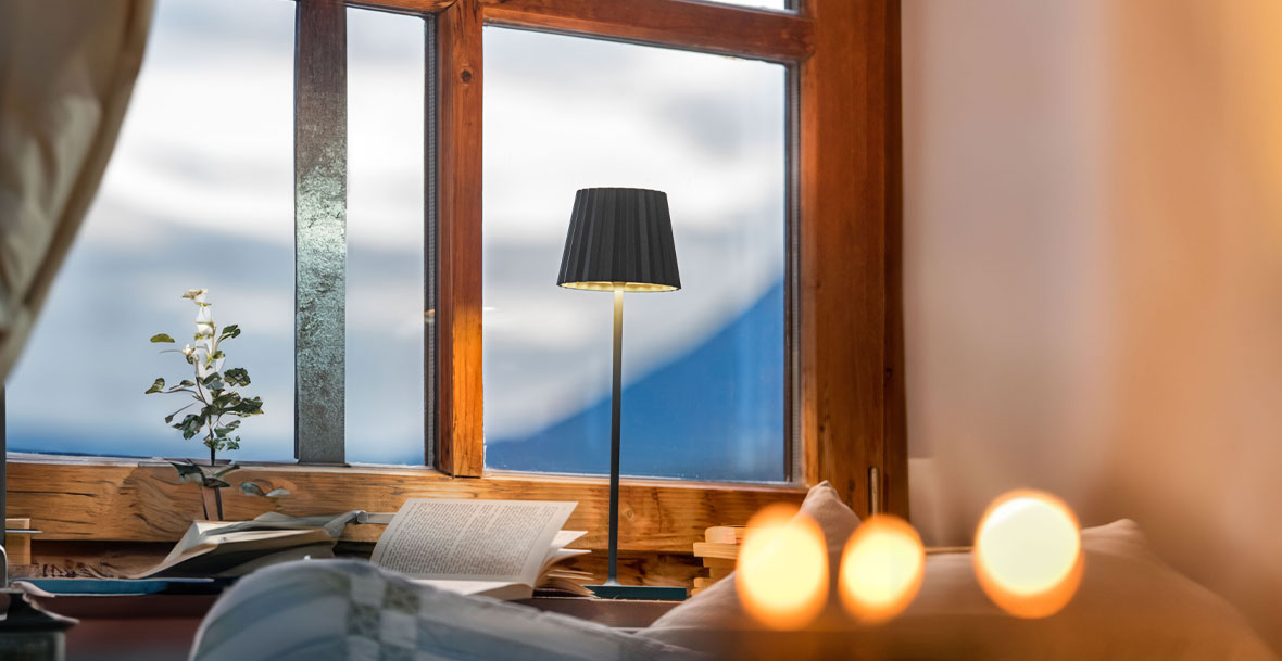 Eine LED Tischleuchte mit gemütlichem Licht an einem Fenster