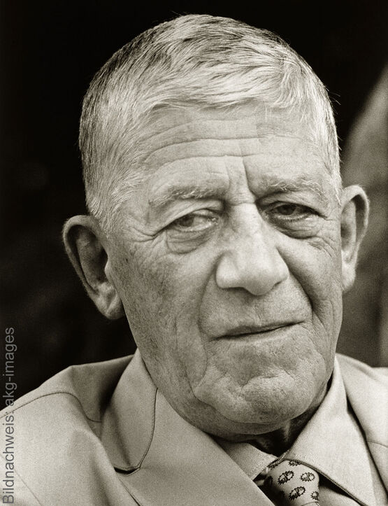 A historical black-and-white photograph, a close-up of the Austrian Expressionist artist and painter Oskar Kokoschka, wearing a suit and a patterned tie.