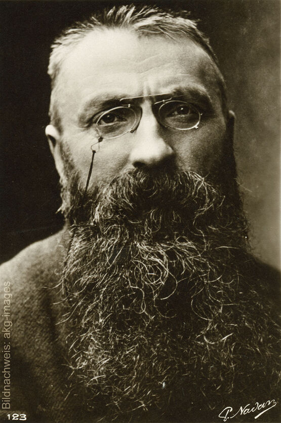 Historisches Porträt des französischen Bildhauers Auguste Rodin mit Brille und langem Bart.