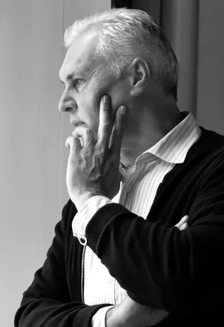 Portrait en noir et blanc de l'artiste Robert Hettich dans une pose pensive.