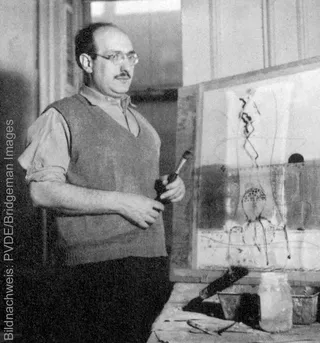 A historical black-and-white photograph of the American painter Mark Rothko in his studio.