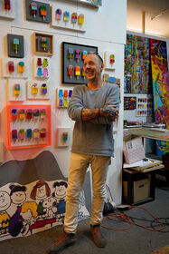 L'artiste Michael Pfannschmidt debout devant ses œuvres d'art dans son atelier