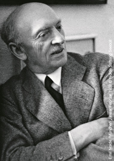 Historische Schwarz-Weiß-Fotografie des expressionistischen Malers Emil Nolde im Tweed-Sakko mit verschränkten Armen.