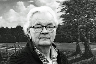 The North German landscape painter Arnold Voet is standing outdoors in front of a natural landscape, looking directly into the camera.