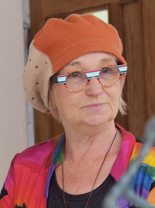 A portrait of the German sculptor Luise Kött-Gärtner wearing a beret and colourful glasses.