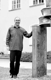 L'artiste Thomas Röthel à côté d'une de ses sculptures