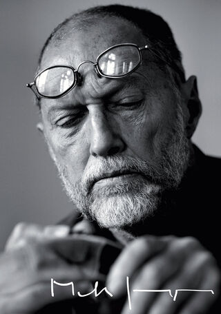 Gros plan sur une photographie en noir et blanc de l'artiste et designer suédois Mats Jonasson, les lunettes posées sur le front, en pleine concentration alors qu'il travaille sur une œuvre d'art en verre.