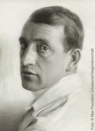 Historisches Schwarz-Weiß-Porträt des Malers Max Pechstein in Nahaufnahme mit Blick zur Kamera.