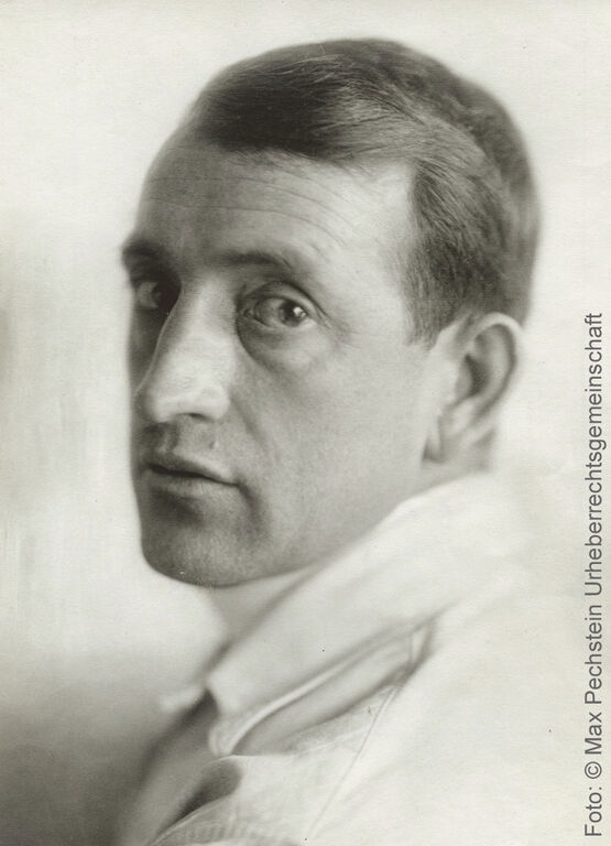 Ett historiskt svartvitt porträtt av målaren Max Pechstein i närbild, där han tittar rakt in i kameran.