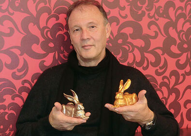 Ottmar Hörl tient dans ses mains deux de ses célèbres sculptures représentant les lapins de Dürer.