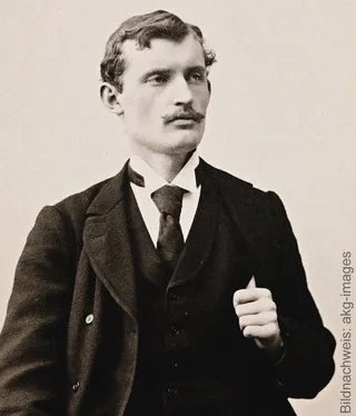 A historical black-and-white portrait of the young painter Edvard Munch in an elegant suit, wearing a tie and a moustache.