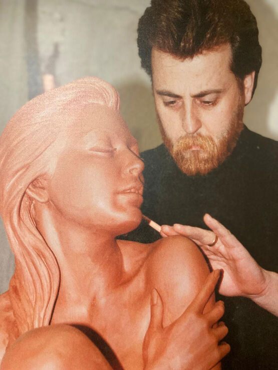 Der spanische Bildhauer Manel Vidal arbeitet mit einem Werkzeug konzentriert an einer weiblichen Tonskulptur.